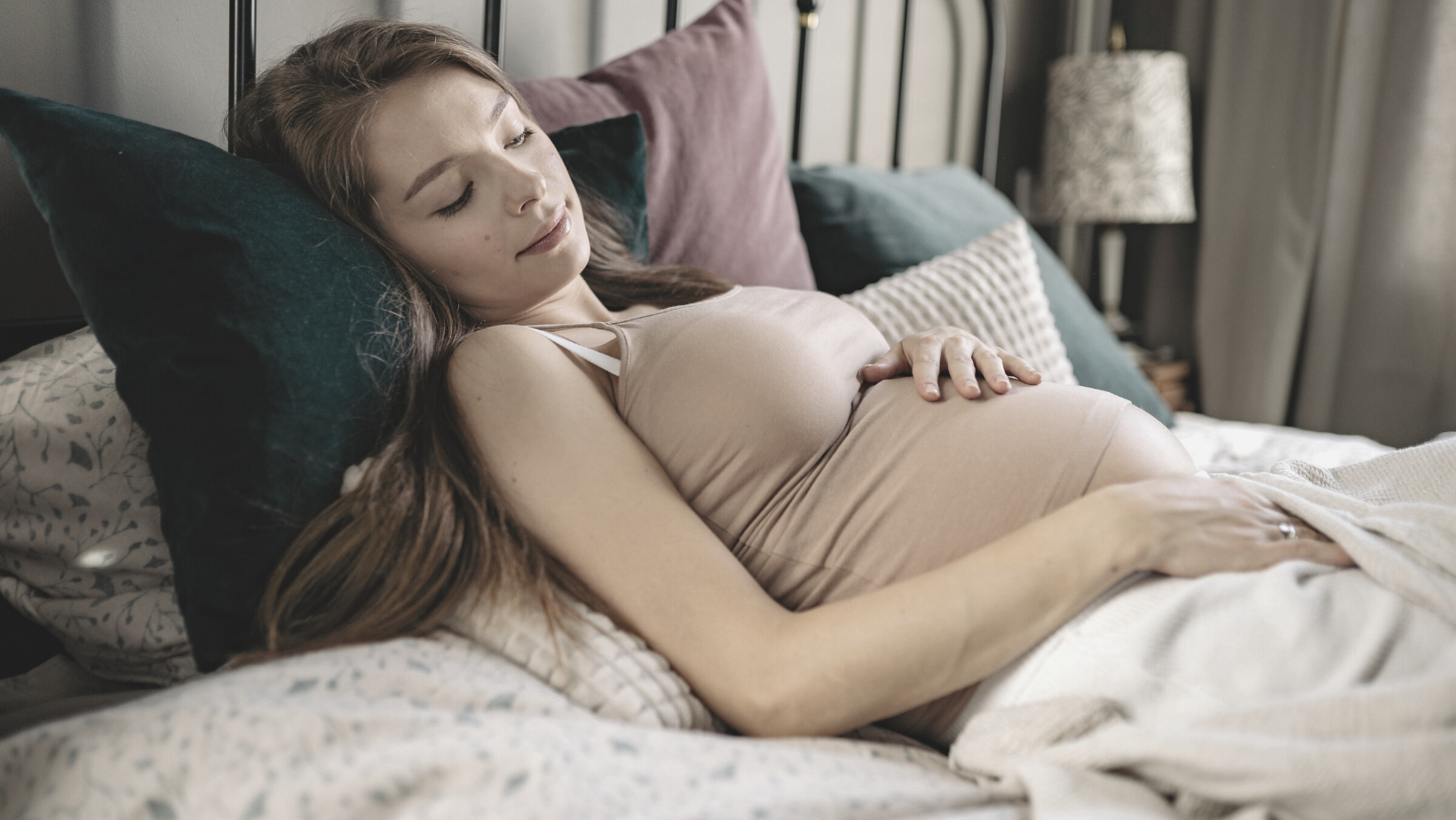 Schwangere Frau entspannt im Bett